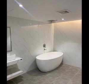 a white bathroom with a tub and a sink at شقق سدو المخدومة in Riyadh