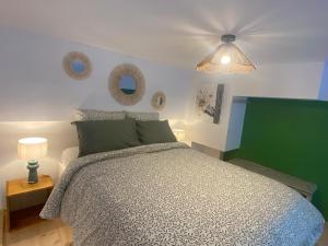 a bedroom with a bed and two mirrors on the wall at Le nid d'Ambre in Étaples