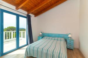 a bedroom with a bed and a large window at Villa Alcumissu in Calangianus +25 photos