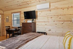 フレデリックスバーグにあるGorgeous Cabin on Main-Steps to Pacific War Museumのベッドと薄型テレビのある寝室