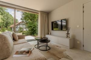 a living room with a couch and a table at Luxury Suite for 2 – Woodz Lodges in Heusden - Zolder