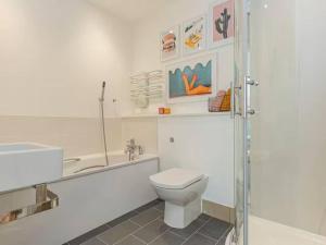 a white bathroom with a toilet and a sink at Pass the Keys Oxford Castle - City Centre Apartment Balcony in Oxford +11 photos