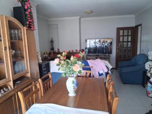 a dining room table with a vase of flowers on it at Apartamento Braga in Braga