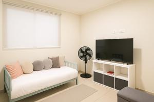 a living room with a couch and a flat screen tv at Costa Rica, San José, Pinares Luxe Apt Near Elite Clinics in San José