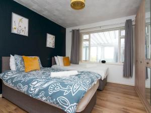 En eller flere senge i et værelse på Pass the Keys Centrally Located Modern Seaside House