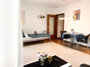 a living room with a bed and a table at Helle 2 Zimmer Wohnung mit Balkon gemütlich & zentral in Aalen