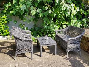 two wicker chairs and a table and a chair at 4 person holiday home in Sønderborg in Sønderborg