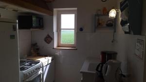 a small kitchen with a stove and a window at Quiet spacious cottage in Marnefer