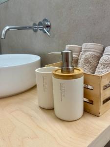 a bathroom counter with two bottles of soap and towels at Beachy & Bright - 2BR with pool - Maré in Lavra