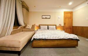 Tân UyênにあるTriệu Nguyễn Hotelのベッドとソファのある寝室