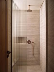 una ducha con puerta de cristal en un baño en Oriana, Beachfront villa, en Zakynthos