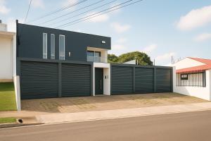 a house with black garage doors on a street at Costa Rica, San José, Pinares Luxe Apt Near Elite Clinics in San José