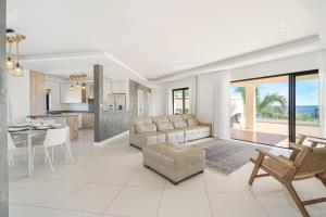 a living room and kitchen with a couch and a table at Skyline Azur - Luxueux Penthouse Front de Mer in Flic-en-Flac