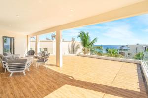 an empty house with a deck with a view of the ocean at Skyline Azur - Luxueux Penthouse Front de Mer in Flic-en-Flac