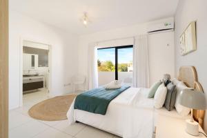 a white bedroom with a large bed and a bathroom at Skyline Azur - Luxueux Penthouse Front de Mer in Flic-en-Flac +27 photos