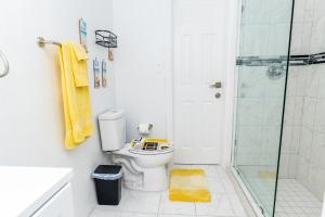 ein Badezimmer mit Toilette und Glasdusche in der Unterkunft Lux Beach Front Retreat Sleeps up to 14 in Nassau