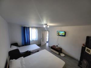 a small room with a bed and a tv on the wall at Gabi in Târgu Ocna