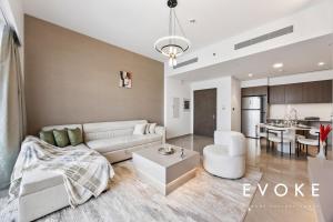 ドバイにあるGrande Residence Burj View 2 BR by Evoke Luxuryの白いソファとキッチンのあるリビングルーム