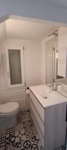 a white bathroom with a sink and a toilet at Isola Rossa Appartamenti Comfort plus in Isola Rossa
