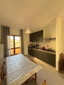 a kitchen with a table and a kitchen with black cabinets at Isola Rossa Appartamenti Comfort plus in Isola Rossa