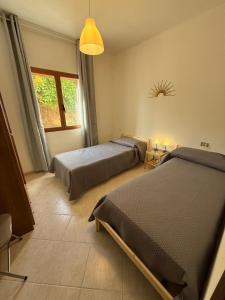 a bedroom with two beds and a window at Isola Rossa Appartamenti Comfort plus in Isola Rossa +69 photos