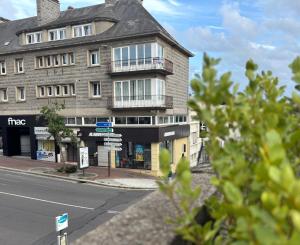 a building on the corner of a street at Cozy Loft tout équipé au cœur de Saint-Lô in Saint Lo