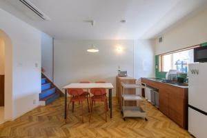 a kitchen with a table and two chairs and a counter at guesthouse YAWNYAWN in Echizen