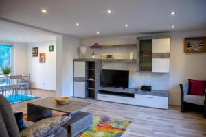 a living room with a flat screen tv and a table at Ferienhaus Am Reiterhof in Templin +8 photos