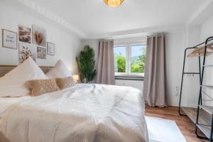 a bedroom with a white bed and a window at Die entspannendste Wohnung am Edersee - SPA Sauna in Giflitz