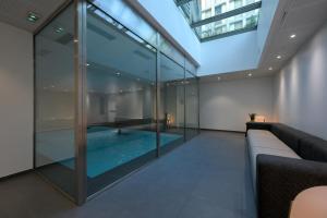 a swimming pool inside of a building with glass walls at Nemea Appart Hotel So Cloud Lyon Gare Part-Dieu in Lyon