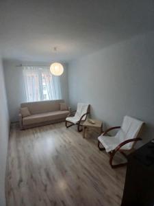 a living room with a couch and two chairs at Mieszkanie Niepodległości in Kraśnik