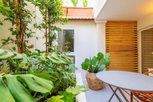 a patio with a table and a bunch of plants at Charming Flat with Patio Lisbon in Bicas