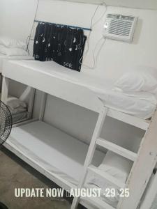 a white bunk bed with a air conditioner on it at Alegreya Homestay + Cafe in General Luna