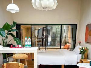 上海市にあるProsperity B&B Downtown Shanghai - Yongkang Road Branchの白いソファとテーブルのあるリビングルーム