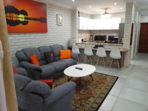 a living room with a couch and a table at Flamboyant Apartments in St Lucia