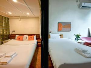 two beds in a hotel room with towels on them at Floral Apart mentYongkang Road in Shanghai
