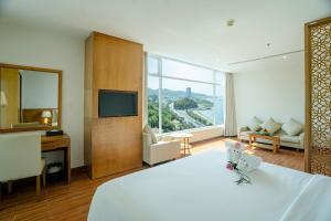 Una habitación de hotel con una cama grande y un televisor. en Glamour Hotel Nha Trang, en Nha Trang
