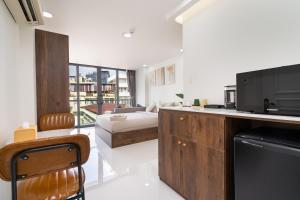 a living room with a couch and a kitchen with a television at Ekomo Home 95 - Metro Ben Thanh in Ho Chi Minh City