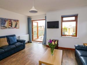 a living room with a couch and a table at Surf View in Kingsbridge