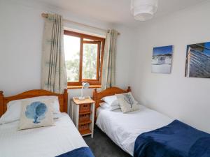 a bedroom with two beds and a window at Surf View in Kingsbridge