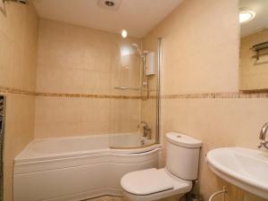 a bathroom with a tub and a toilet and a sink at Surf View in Kingsbridge +24 photos