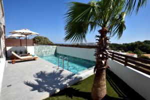 a palm tree sitting next to a swimming pool at Villa 101 Rhodes in Ixia