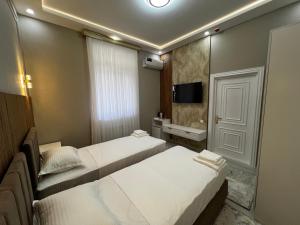 En eller flere senge i et værelse på Hotel Zafarbek Plaza