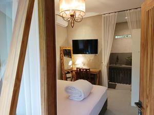 Habitación con cama con espejo y mesa. en Victory Beloved House Sanur Private Rooms Villa Bali, en Sanur
