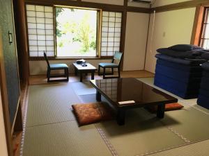 a living room with chairs and a table and a couch at Samurai Hotel Naraiso in Narai