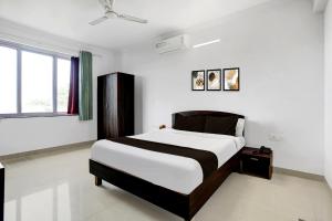a bedroom with a bed and a window at Super Hotel O Porvorim in Goa