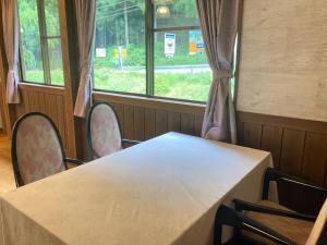a table and chairs in a room with windows at GuestHouse HESTA Itadorigawa Onsen - Vacation STAY 89862v in Gujo +6 photos
