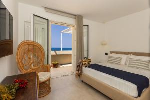 a bedroom with a bed and a balcony with the ocean at AUREA collection SEA VIEW in Cefalù