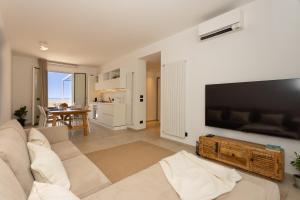 a living room with a couch and a flat screen tv at AUREA collection SEA VIEW in Cefalù