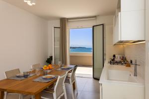 a kitchen and dining room with a table and a view of the ocean at AUREA collection SEA VIEW in Cefalù